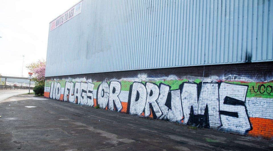 Graffiti reading "NO FLAGS OR DRUMS".