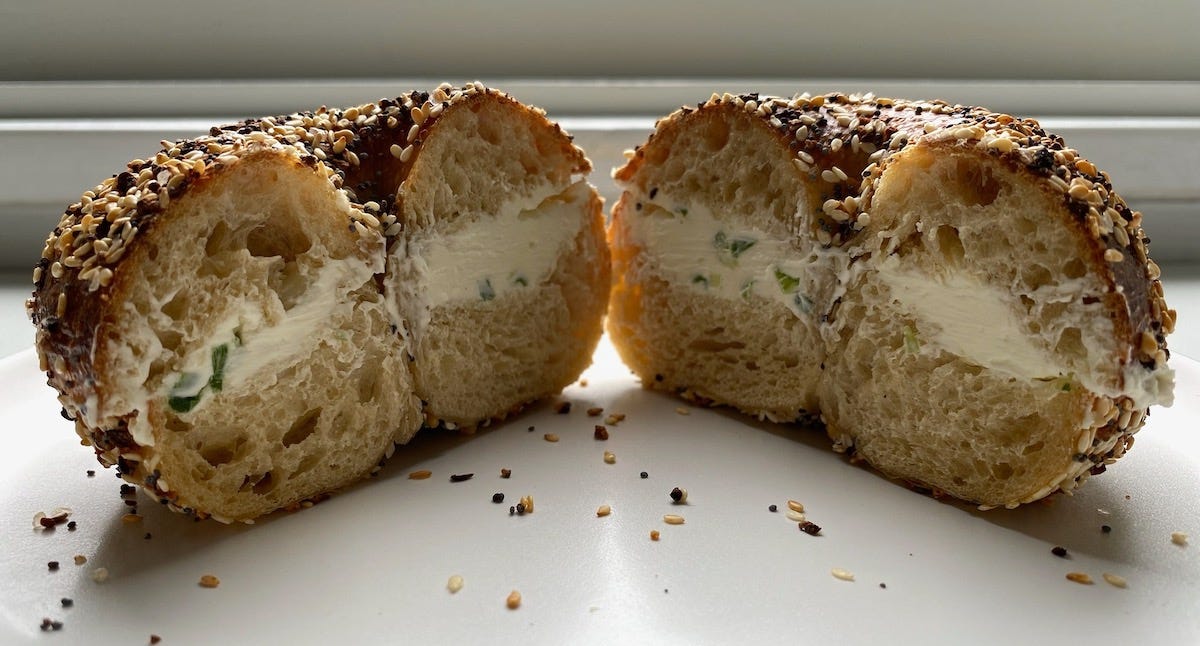 Everything bagel cut open with scallion cream cheese inside. 