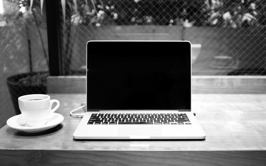 laptop computer beside coffee mug