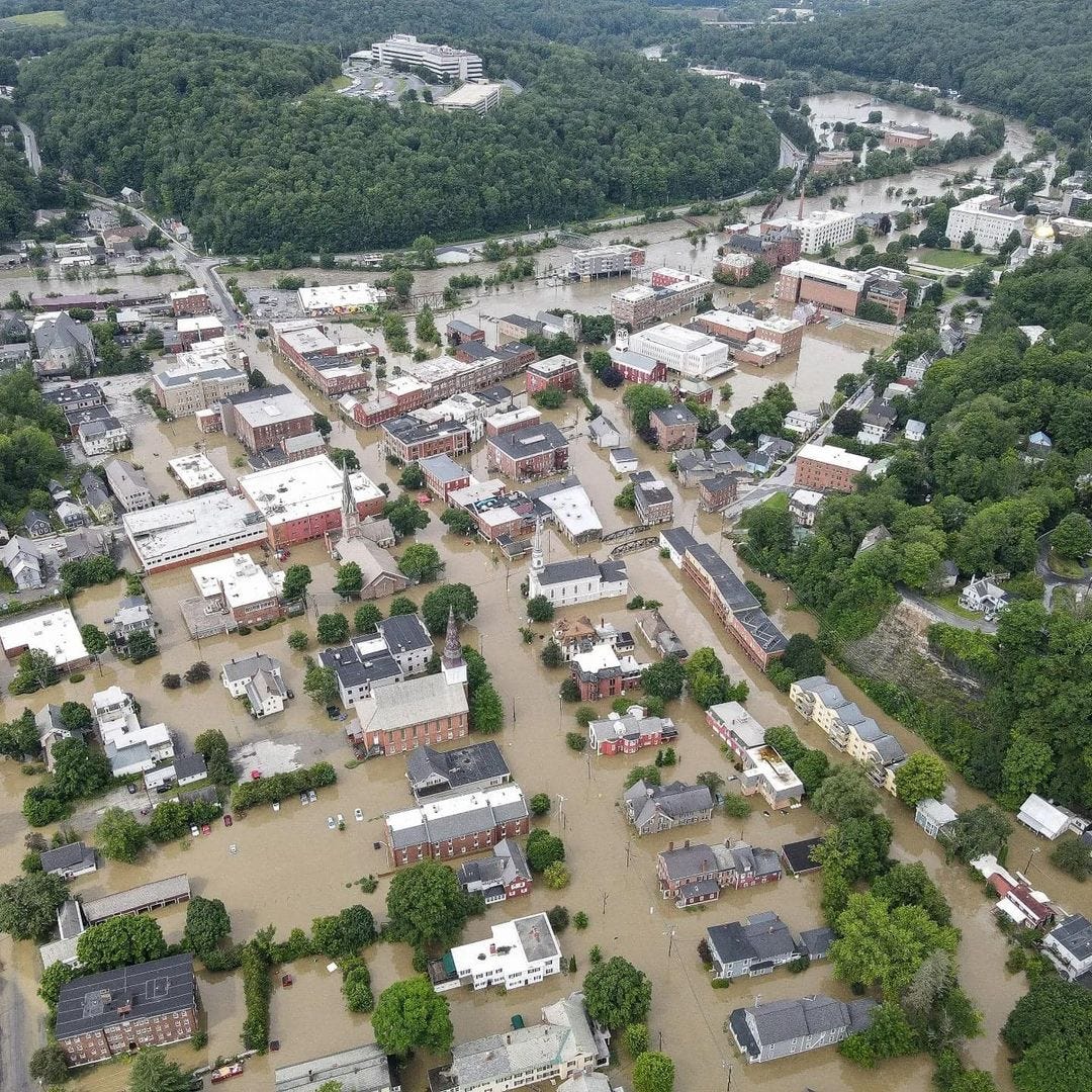 An arial view of Montpelier Vermont's downtown after the floods. The overflowed river at the top of the frame, all the buildings are standing in brown water. 