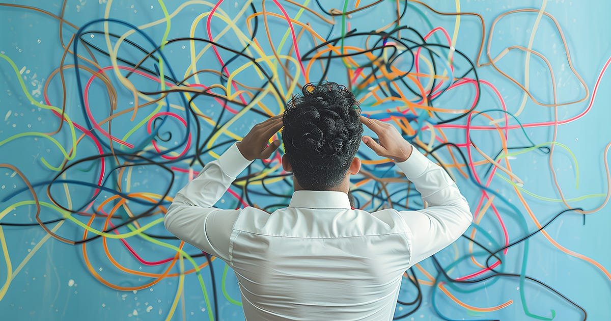 A figure holding his hands to his head in confusion as he stares at a wall with a tangled mess of coloured lines representing a web of decisions.