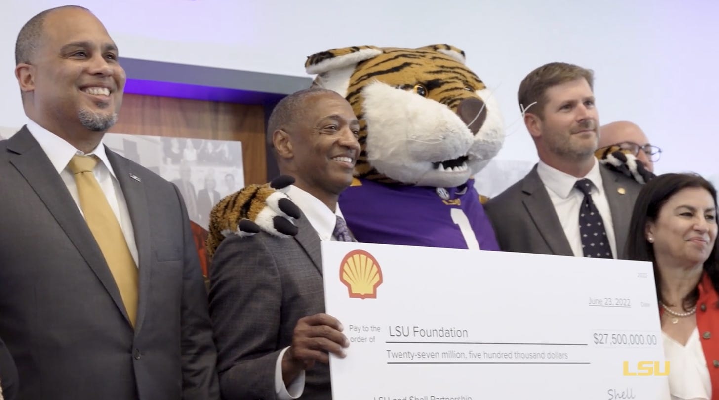 LSU President William F. Tate IV, second from left, poses with LSU mascot Mike the Tiger in 2022 after receiving a donation from Shell for the university's Institute for Innovation in Energy.