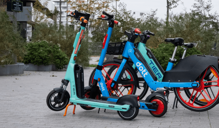 e-scooters and e-bikes, parked on pavement