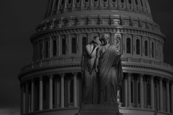 A black and white photograph of the Capitol dome and the Peace monument.