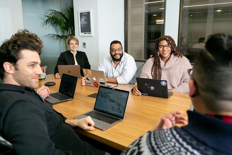 A gorup of office workers sitting around a table.