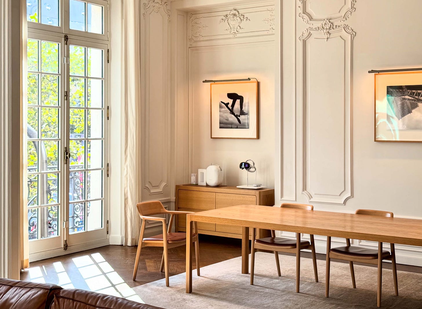 The upper level of Apple Champs-Élysées. Light streams in through a window, and a single Hiroshima chair is pushed away from the table.