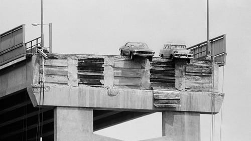 Black and white image of cars hanging over Hobart's Tasman Bridge in 1975 after a section was knocked down by a ship