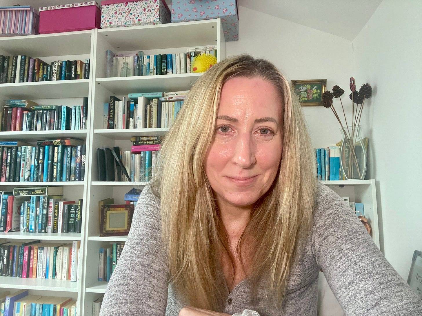 Nicola seated at her desk in front of bookshelves