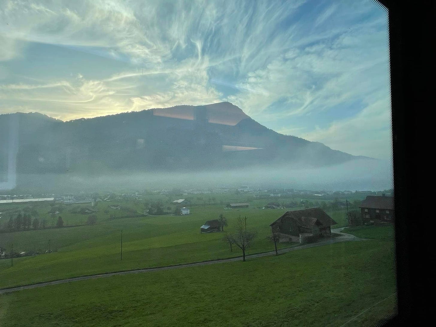 May be an image of train, fog and mountain