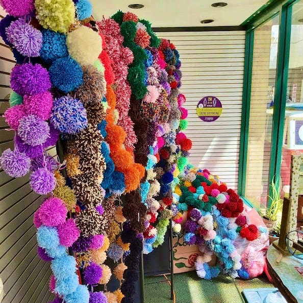 Colourful strings of pompoms stored in a shop unit.