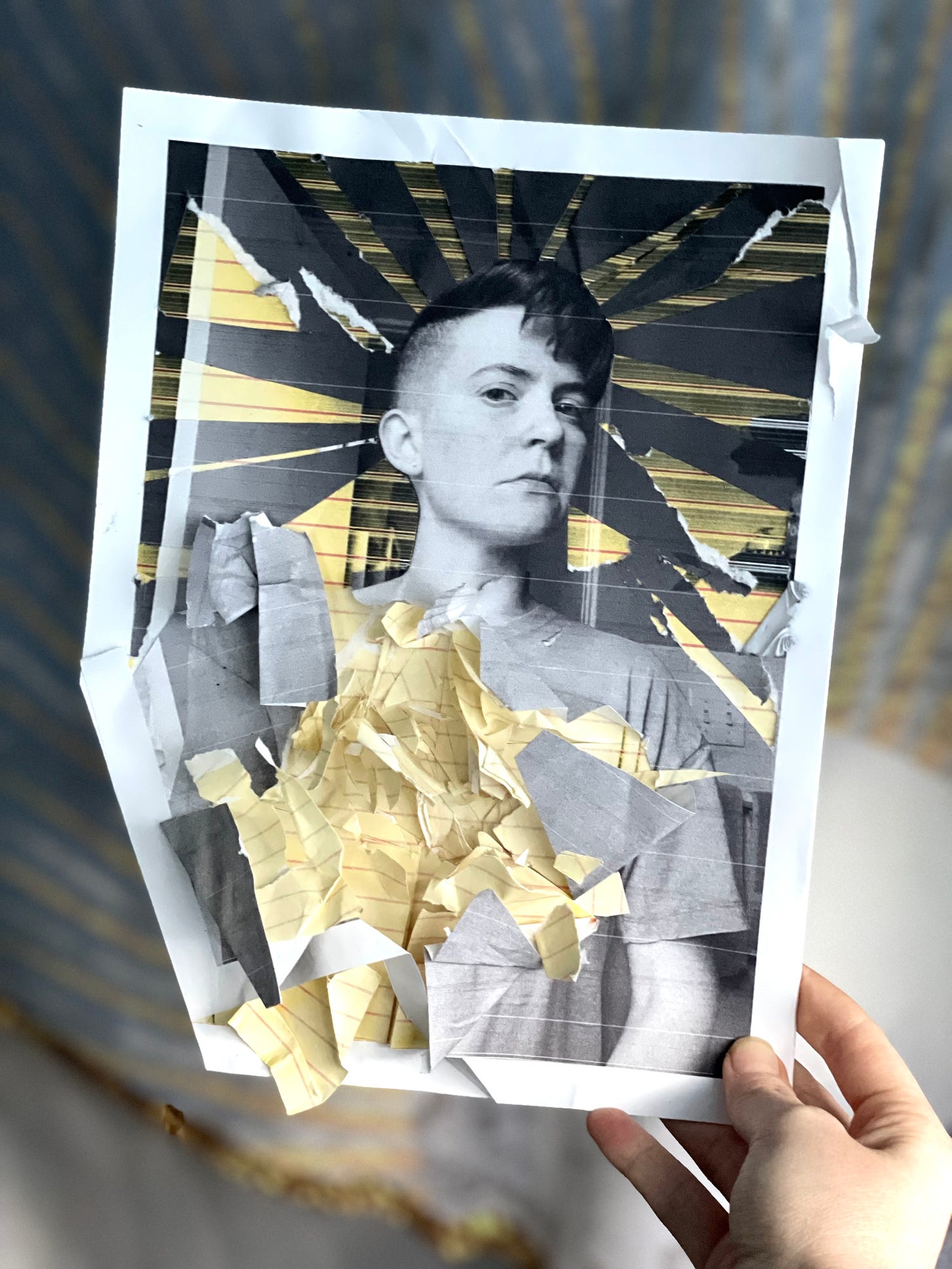 Hand cut collage of a black and white portrait of Lyss, their face posed slightly angled to the side. They are staring down the camera with a neutral expression on their face. Pieces of the collage are cut away to reveal gold paper underneath, with rays of gold moving from their head, and crumbled paper bits of gold bursting from their chest with a 3d effect.