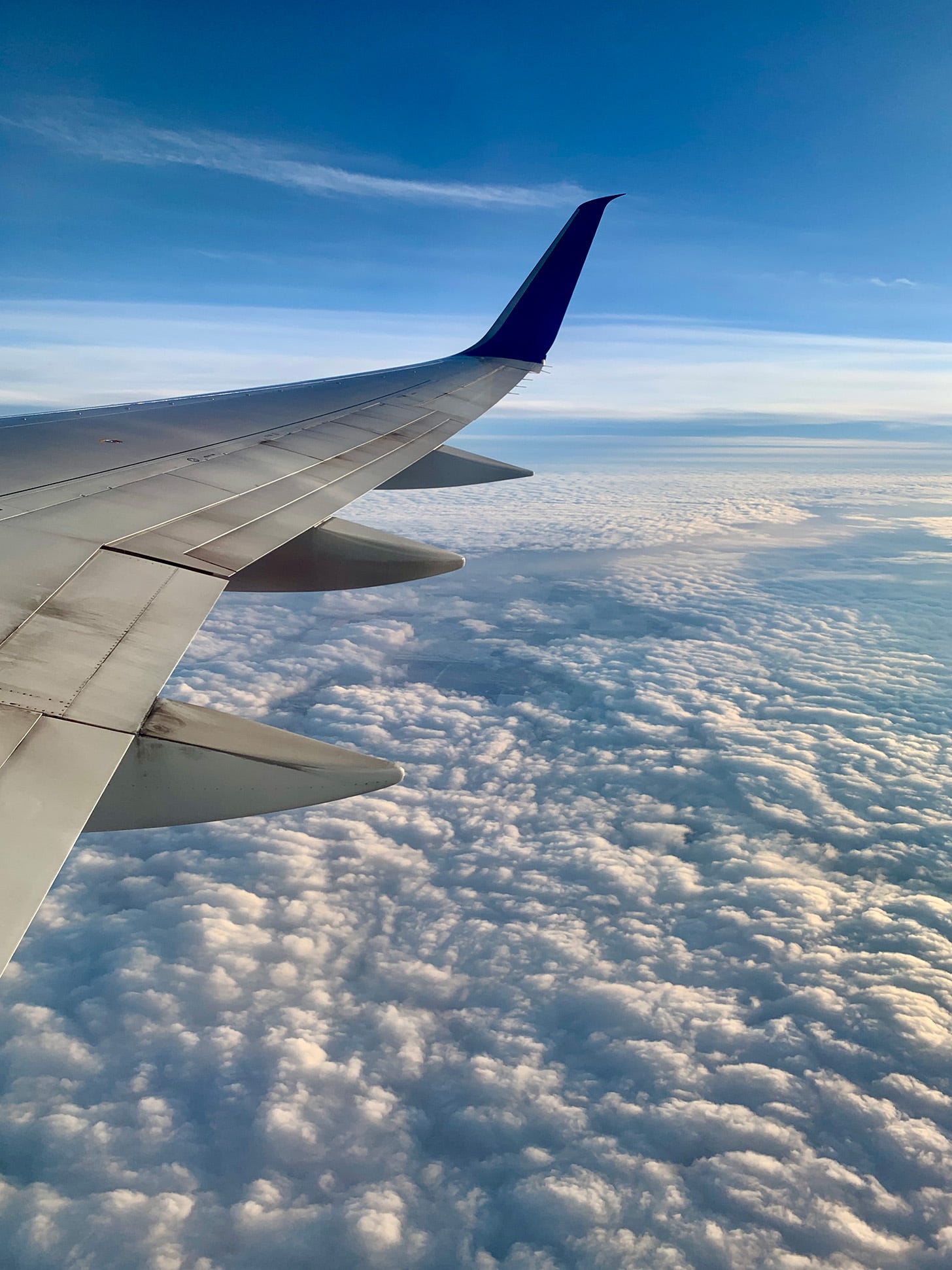 Photo of a plane wing over cloud cover