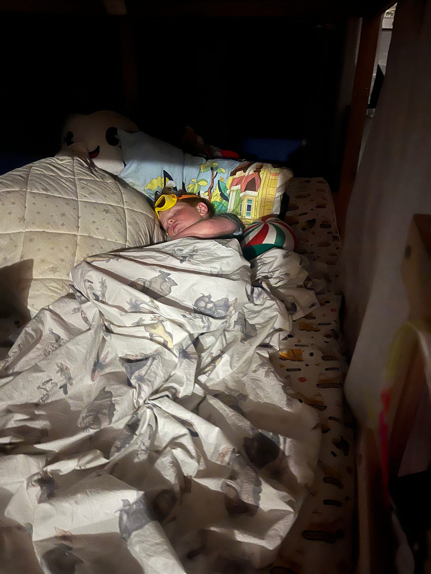 A child sleeping in yellow construction goggles