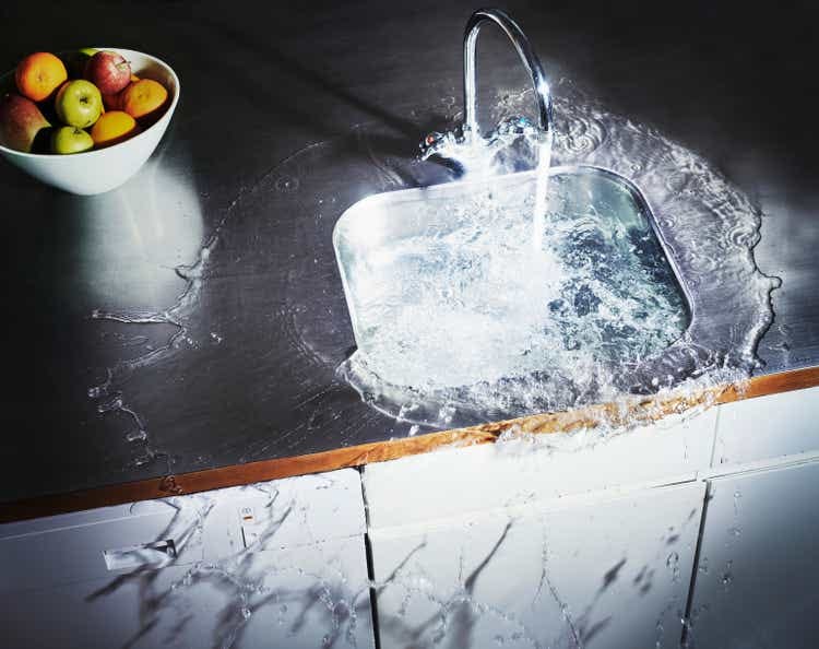 Water overflowing in kitchen sink, elevated view