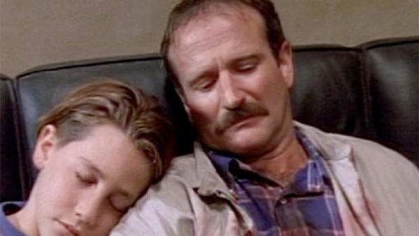 This still image from Homicide: Life on the Street's Season 2 premiere episode "Bop Gun" shows Iowa tourist Robert Ellison (played by Robin Williams) and his son, Matt Ellison (played by a young Jake Gyllenhaal), sitting on a couch in the Baltimore Homicide Squad after Robert's wife (and Matt's mother) is shot to death during a street holdup. The sleeping Matt sits to Ellison's right with his head on his father's shoulder, while Robert looks down in grief. This still image from Homicide: Life on the Street's Season 2 premiere episode "Bop Gun" shows Iowa tourist Robert Ellison (played by Robin Williams) and his son, Matt Ellison (played by a young Jake Gyllenhaal), sitting on a couch in the Baltimore Homicide Squad after Robert's wife (and Matt's mother) is shot to death during a street holdup. The sleeping Matt sits to Ellison's right with his head on his father's shoulder, while Robert looks down in grief.
