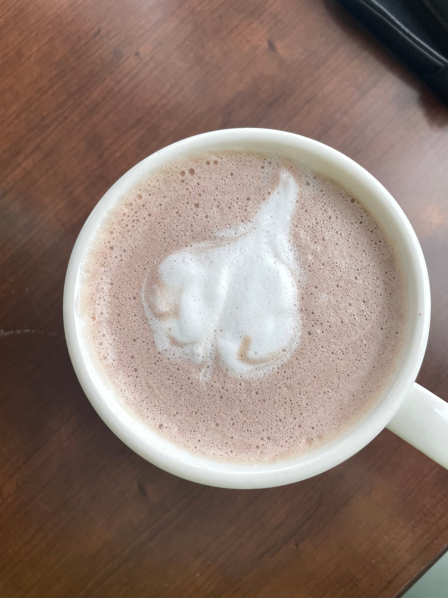 A cup of vanilla latte with a heart drawn with foam