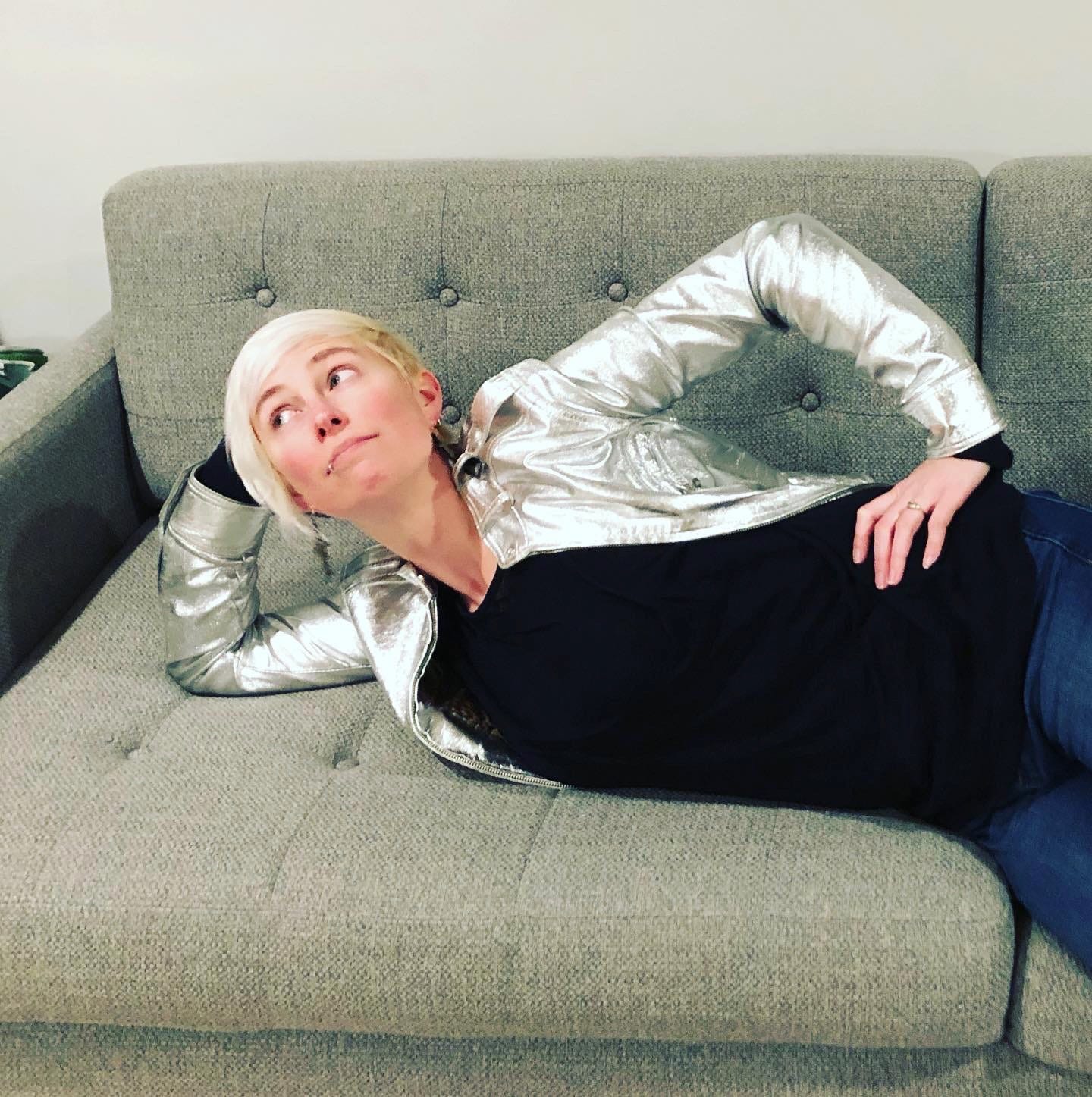 Jessie lying on a couch wearing a ridiculous silver leather jacket