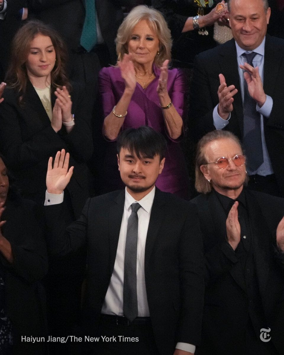 Brandon Tsay, pictured in a dark suit standing and waving, is in the audience for President Biden's 2023 State of the Union address. Photo by Haiyun Jiang/The New York Times.