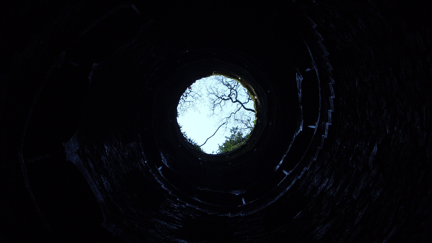 Looking up from the bottom of what appears to be a well, as the light teases you stranded at the bottom.