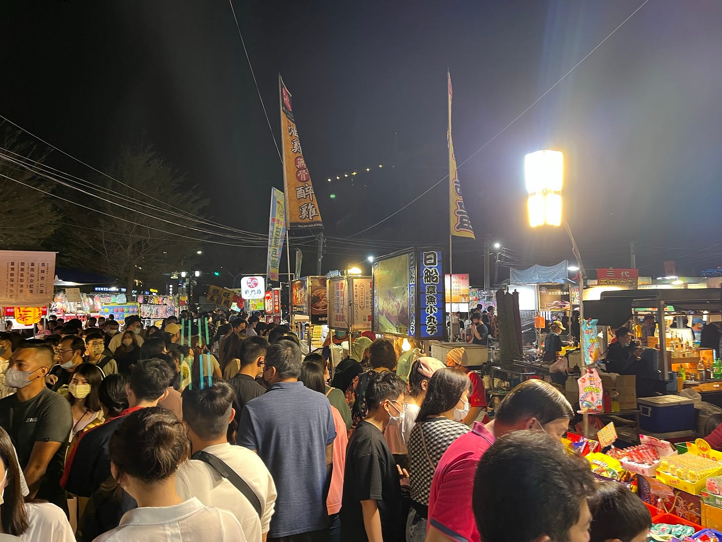 People are tightly packed into lanes between food stalls at Tainan's Garden 花園 night market.
