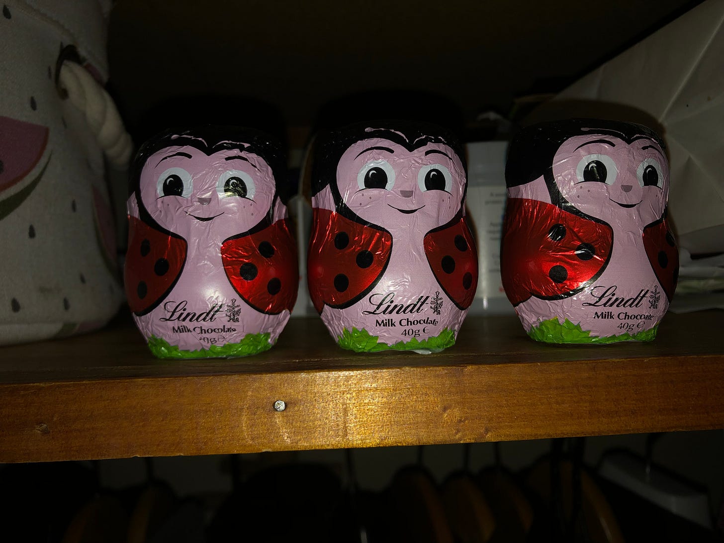 three lady bug easter eggs on a shelf