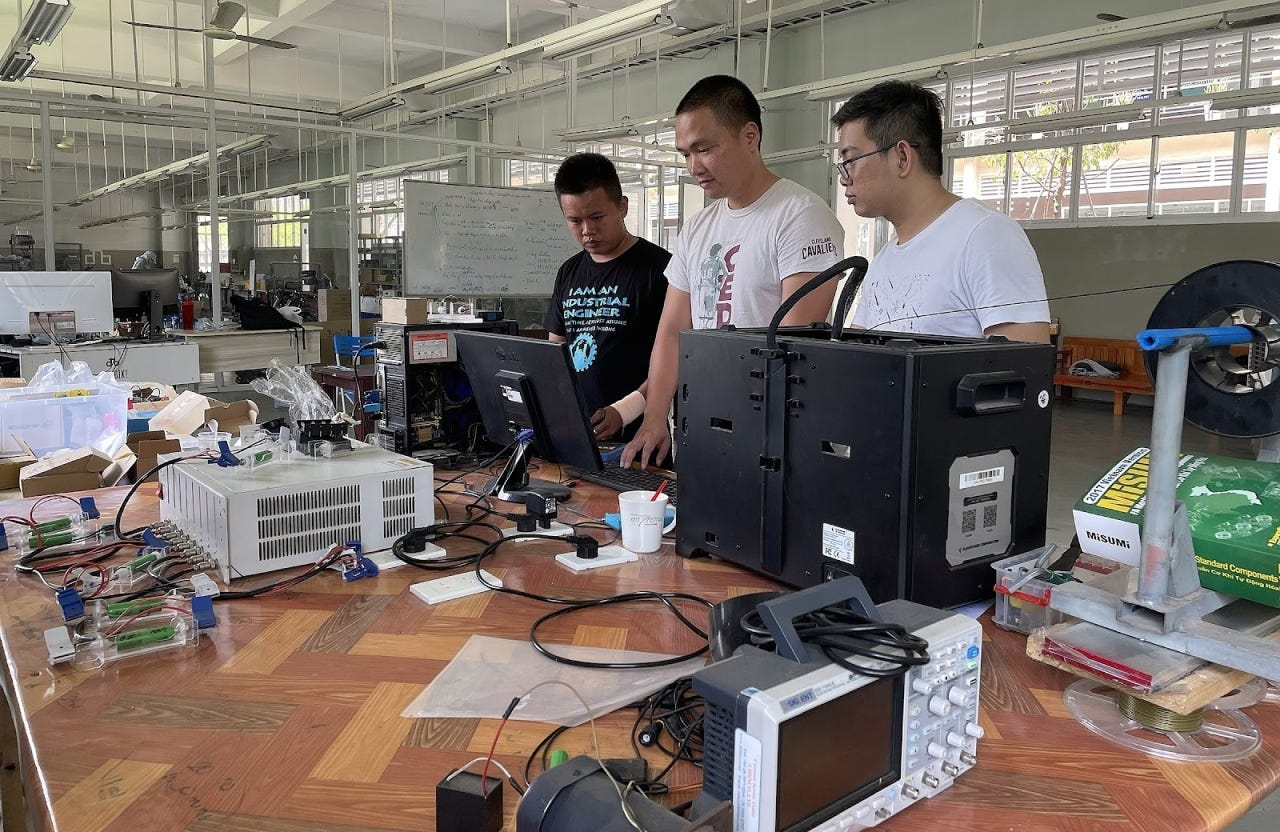 Cảnh Sơn (ở giữa) đang làm việc cùng đội ngũ tại nhà máy ở Bình Dương. Ảnh: Ny Bùi.