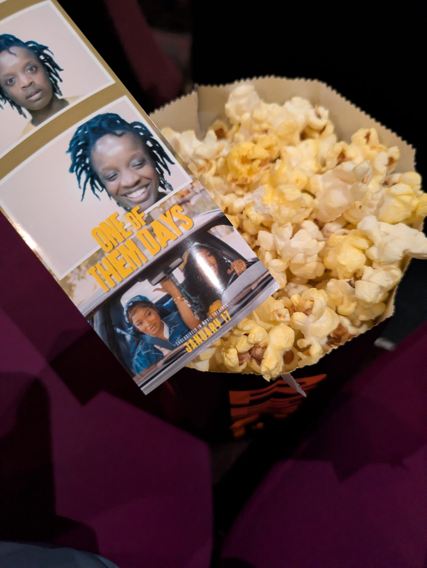 A photo booth image of a Black woman with One of the Days logos and imagery framing the printed photos with a bag of popcorn in the background. 