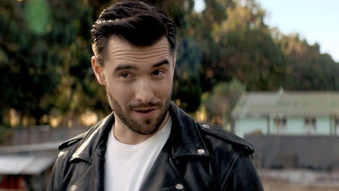 This image shows Time Agent Krasko (played by Joshua Bowman) wearing a leather jacket and sneering at the off-camera Thirteenth Doctor. This image shows Time Agent Krasko (played by Joshua Bowman) wearing a leather jacket and sneering at the off-camera Thirteenth Doctor.