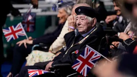 PA A Normandy veteran sat in a wheelchair attending the UK's national commemorative event for the 80th anniversary of D-Day