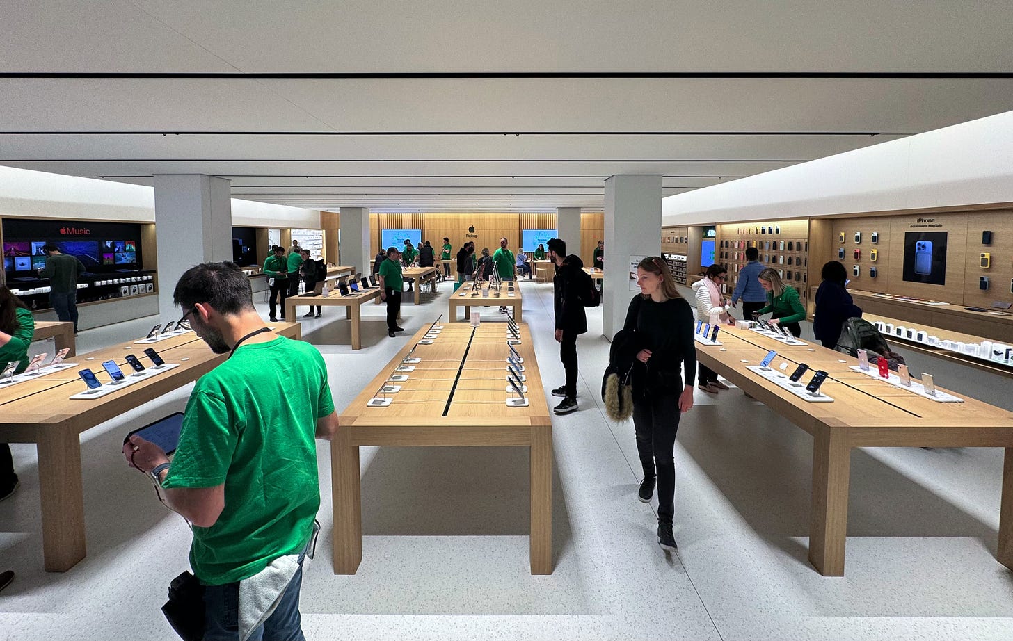 The interior of Apple Parly 2 photographed from the front of the store. In the foreground are tables and in the background is an Apple Pickup counter.