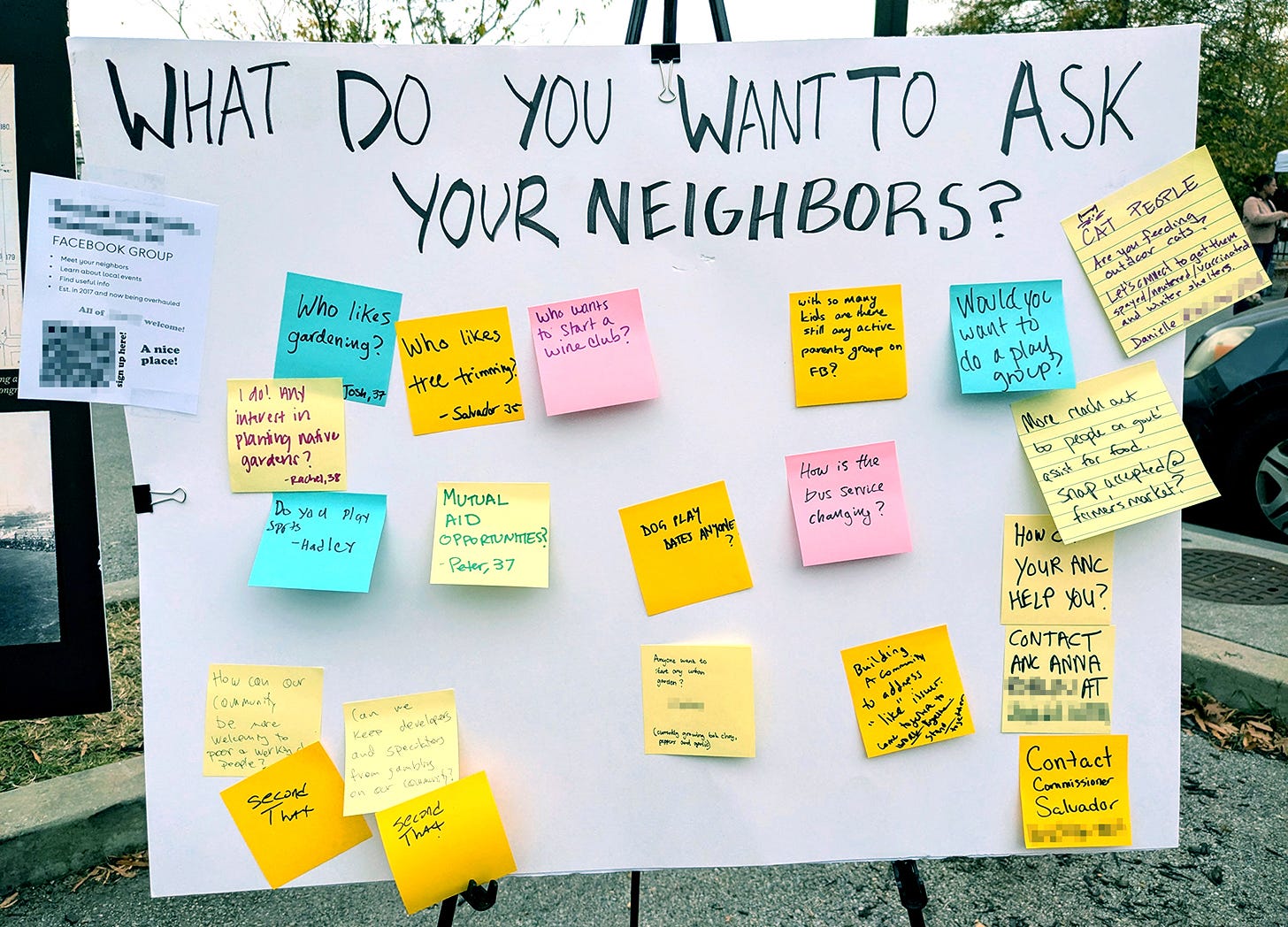 a photo of a poster board outside, with the title "What Do You Want to Ask Your Neighbors?"