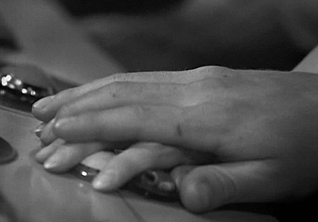 A screenshot of Leo placing his hand on Tanya's in The Wheel in Space (1968)