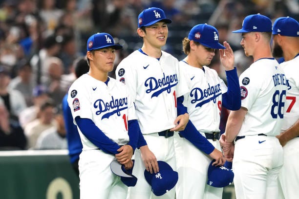 Yoshinobu Yamamoto and Roki Sasaki of the Los Angeles Dodgers line up prior to the game against Hanshin Tigers at Tokyo Dome on March 16, 2025 in...