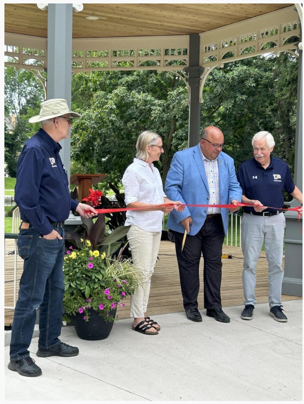 Elected officials and dignitaries preparing to cut the ribbon on the bandstand