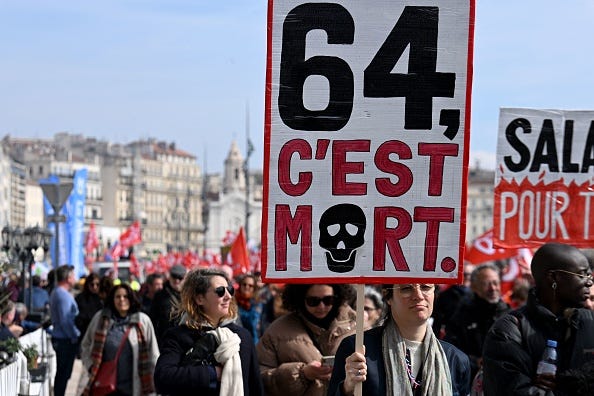People protesting on the street in France. Sign reads 64 C'est Mort