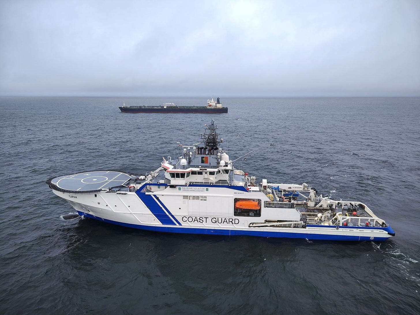 Finnish Border Guard's ship Turva and oil tanker Eagle S sail on the sea outside the Porkkalanniemi, Finland