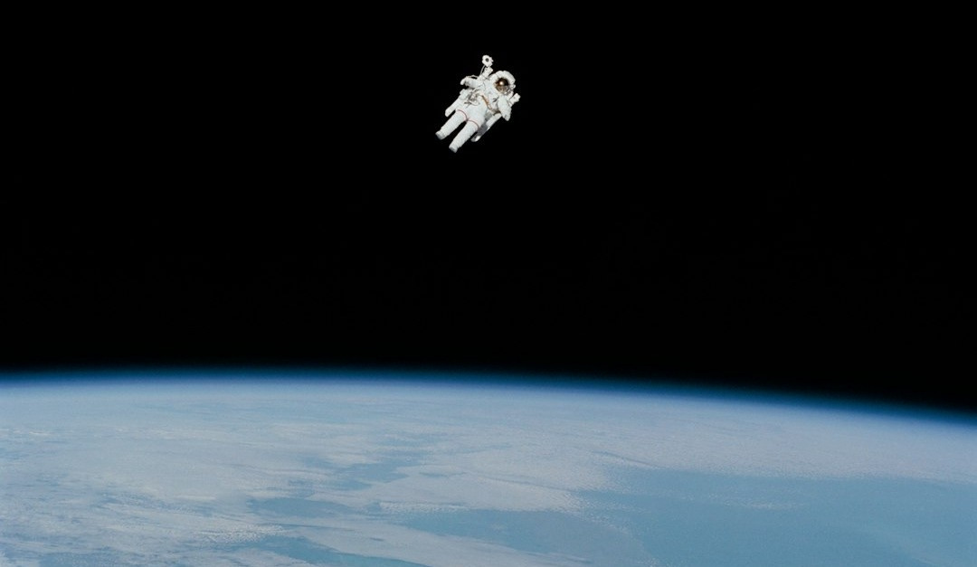 astronaut in spacesuit floating in space