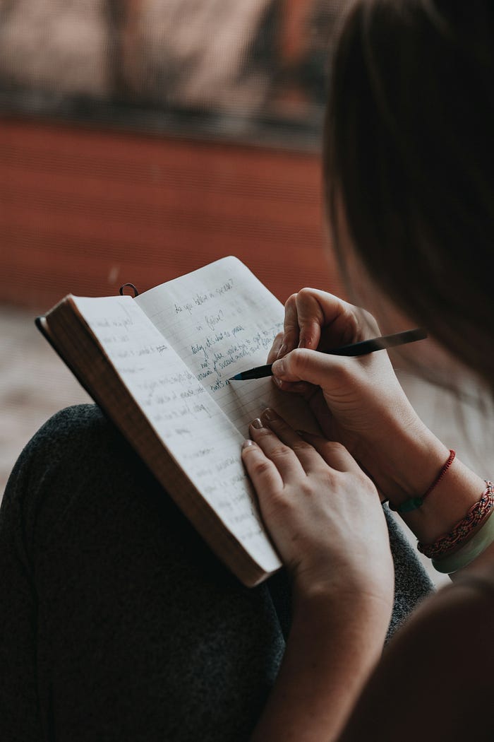 Woman writing in journal.