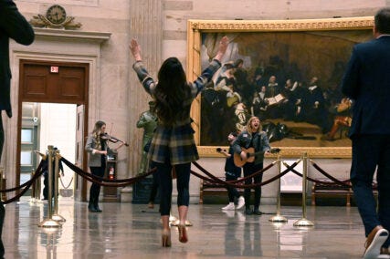 Rep. Lauren Boebert (R-Co), center, raises her arms during a worship service led by musician Sean Feucht, right, in the rotunda of the U.S. Capitol, March 9, 2023, in Washington. RNS photo by Jack Jenkins