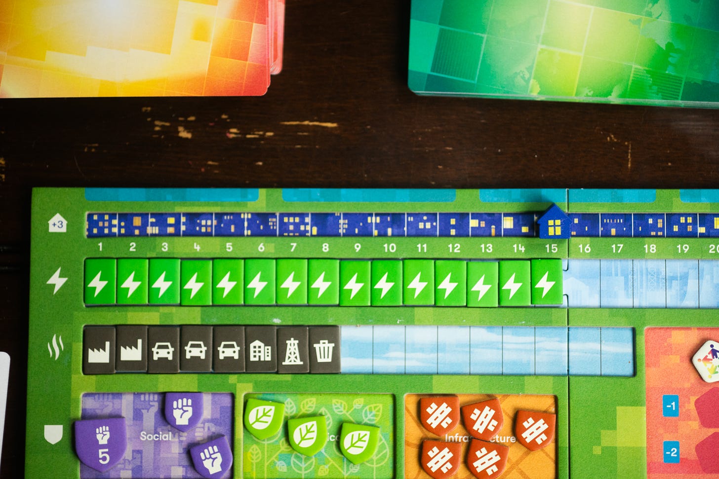 A player board for the game Daybreak, with various resilience tokens, emissions, and energy tokens displayed.