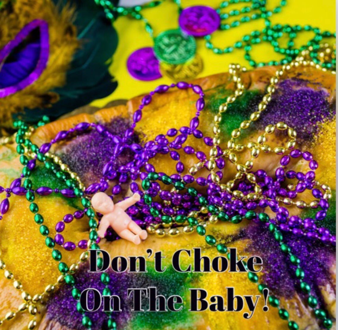 Photo of Mardi Gras beads, mask, and plastic baby from King Cake.