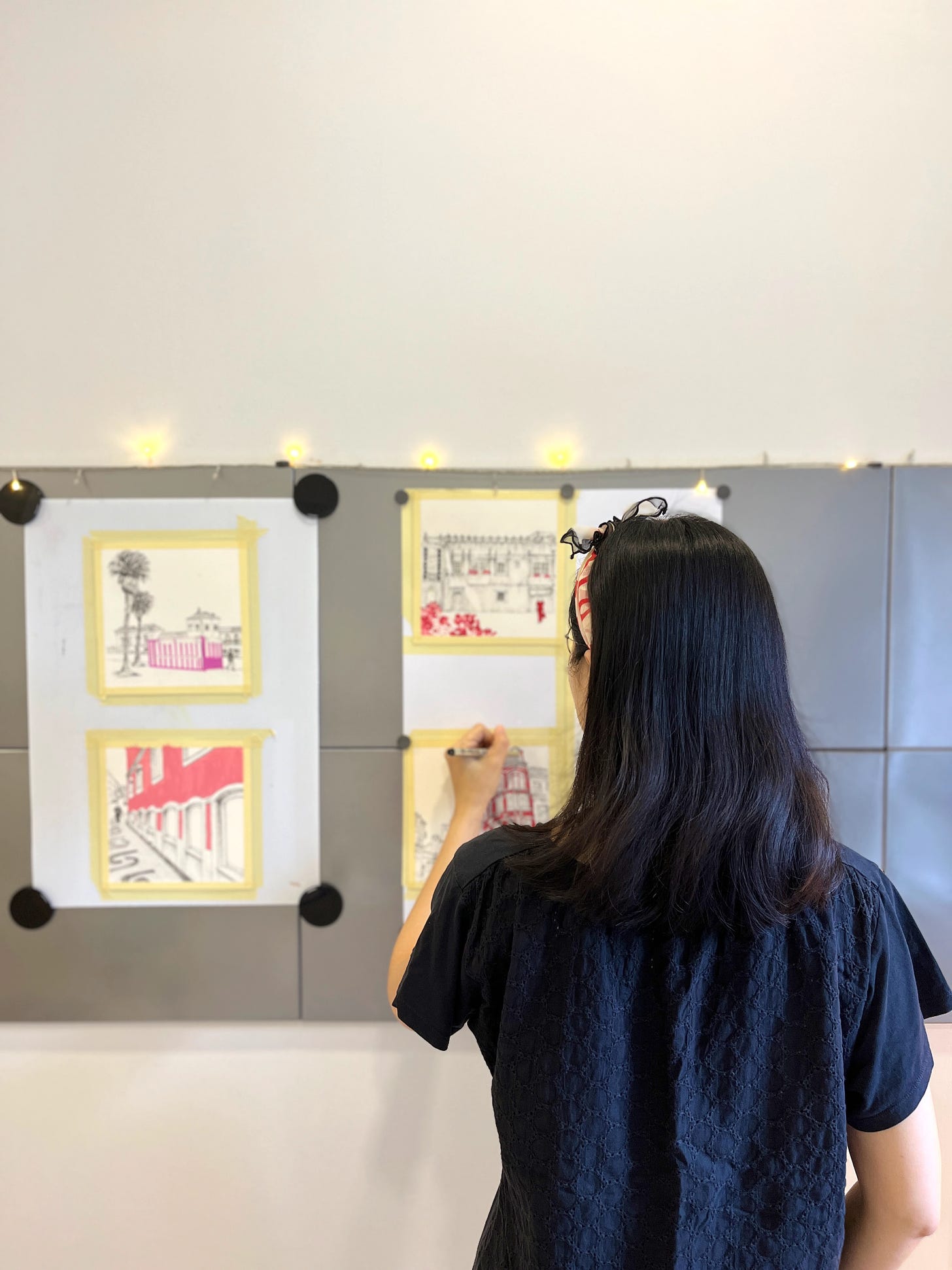 Image: photo of me drawing during the creation of Boa Tarde, Portugal collection. Using the metal memo board as my easel. 