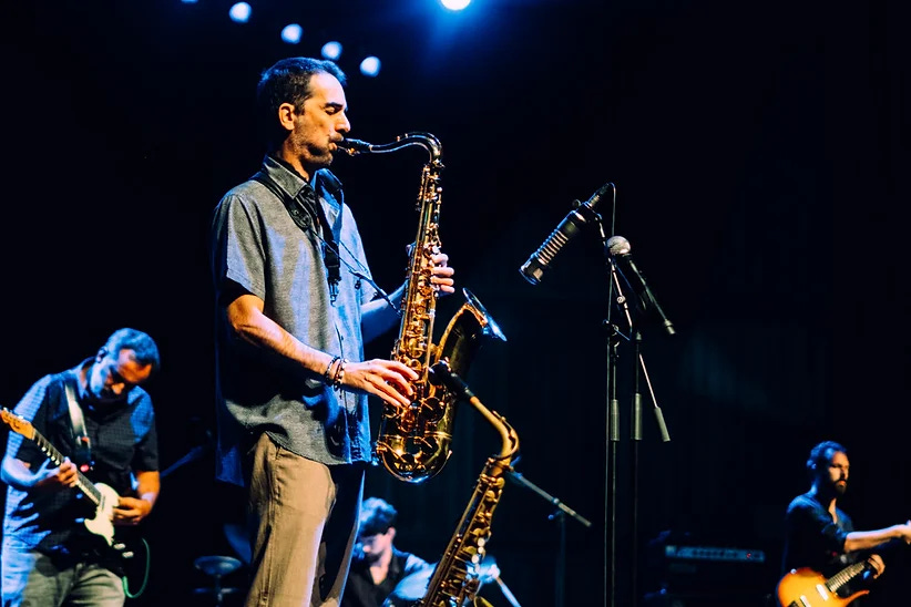 José Lencastre playing saxophone with a guitarist, bassist, and drummer behind him