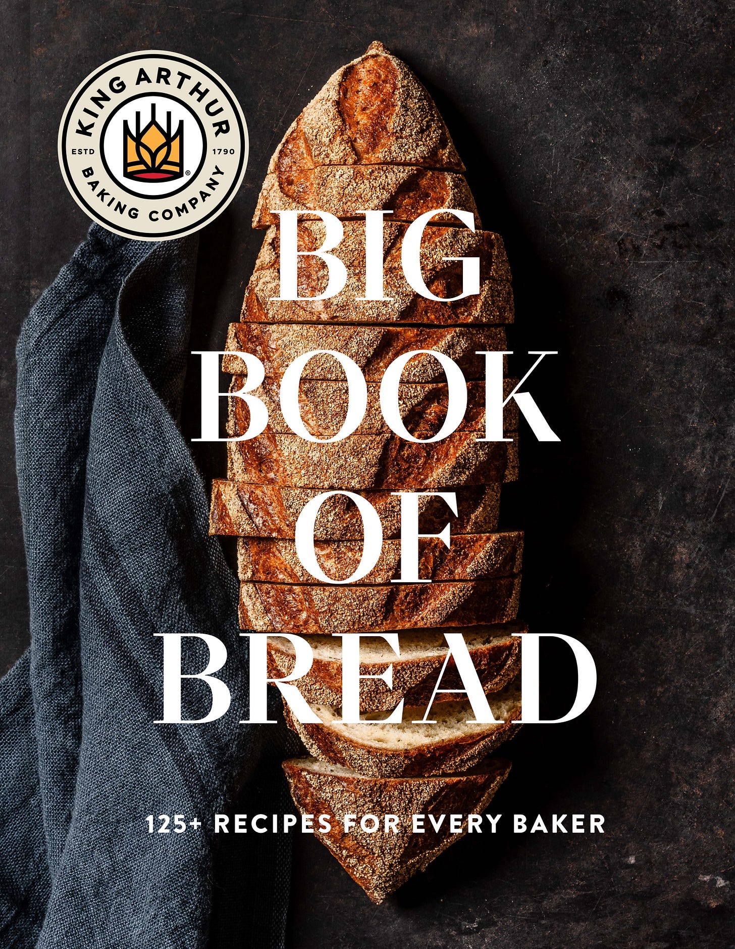 cover of big book of bread with a sliced loaf on dark background.