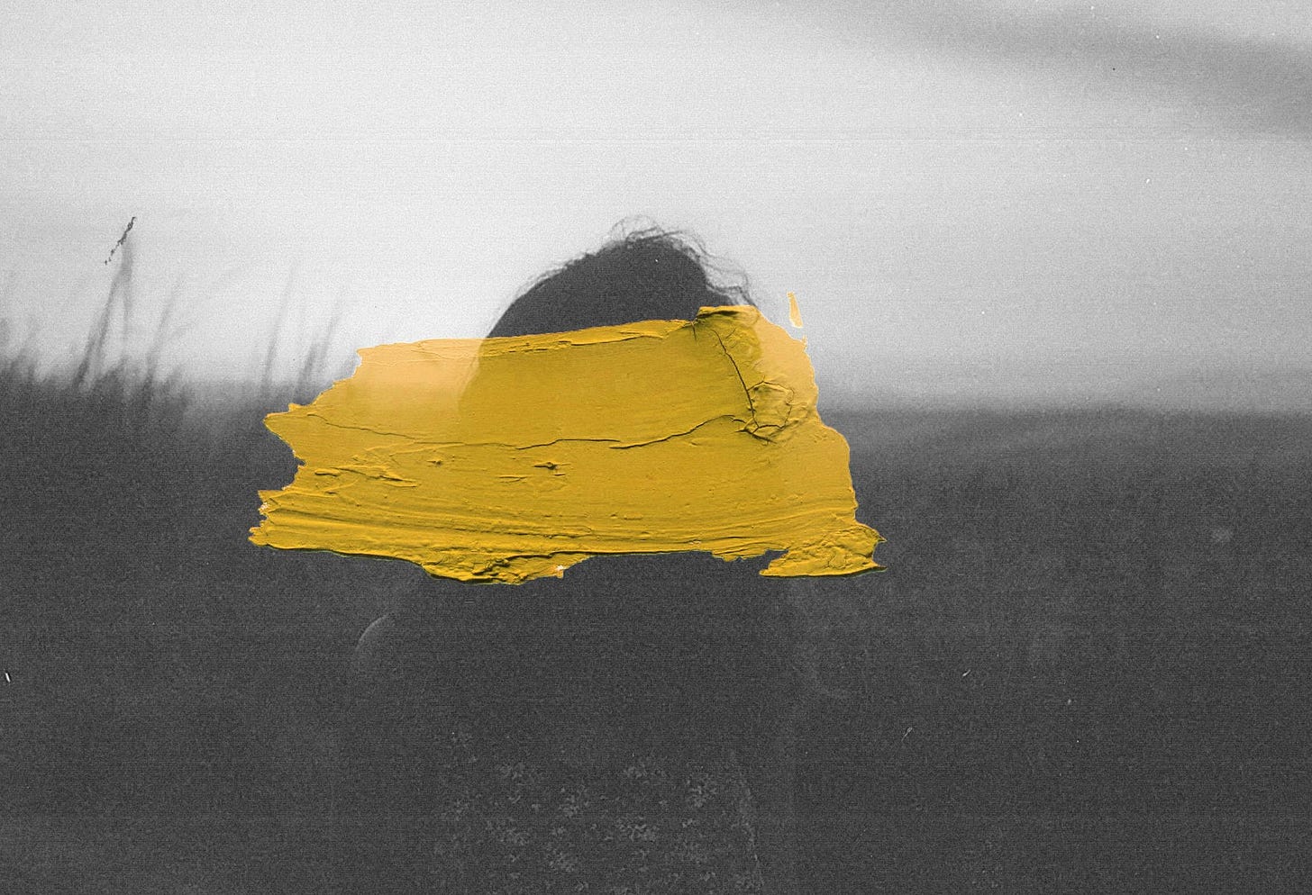Yellow paint is smeared haphazardly on a black-and-white photograph of a woman.