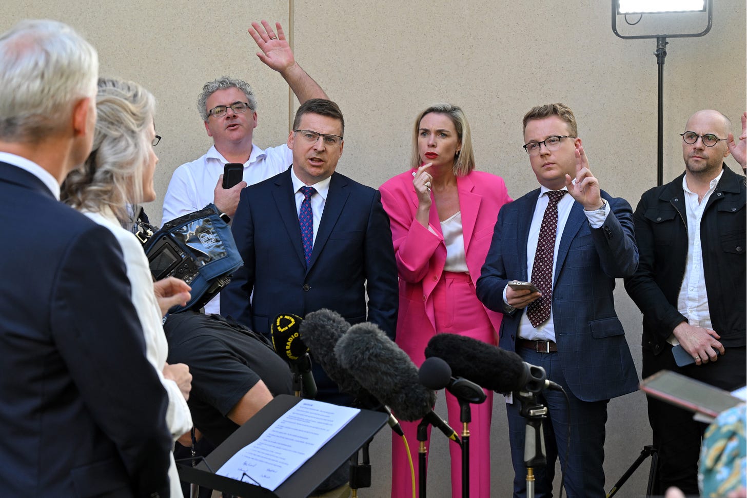 Journalists yelling questions to Minister for Immigration Andrew Giles at Parliament House, March 27, 2024. Mick Tsikas/AAP