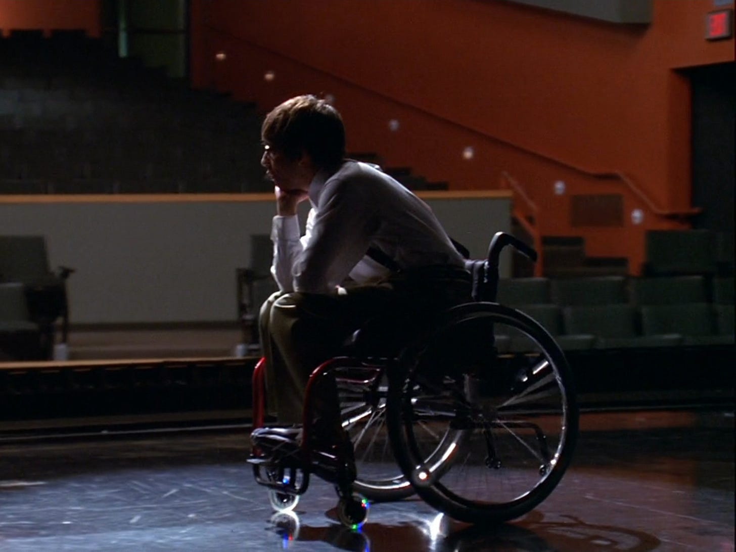 Kevin McHale sitting in a wheelchair on 'Glee.'