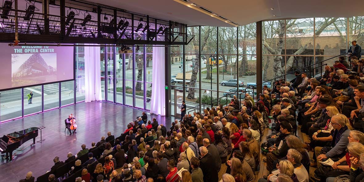 People are packed into Seattle Opera's Tagney Jones Hall for a performance given by a cellist