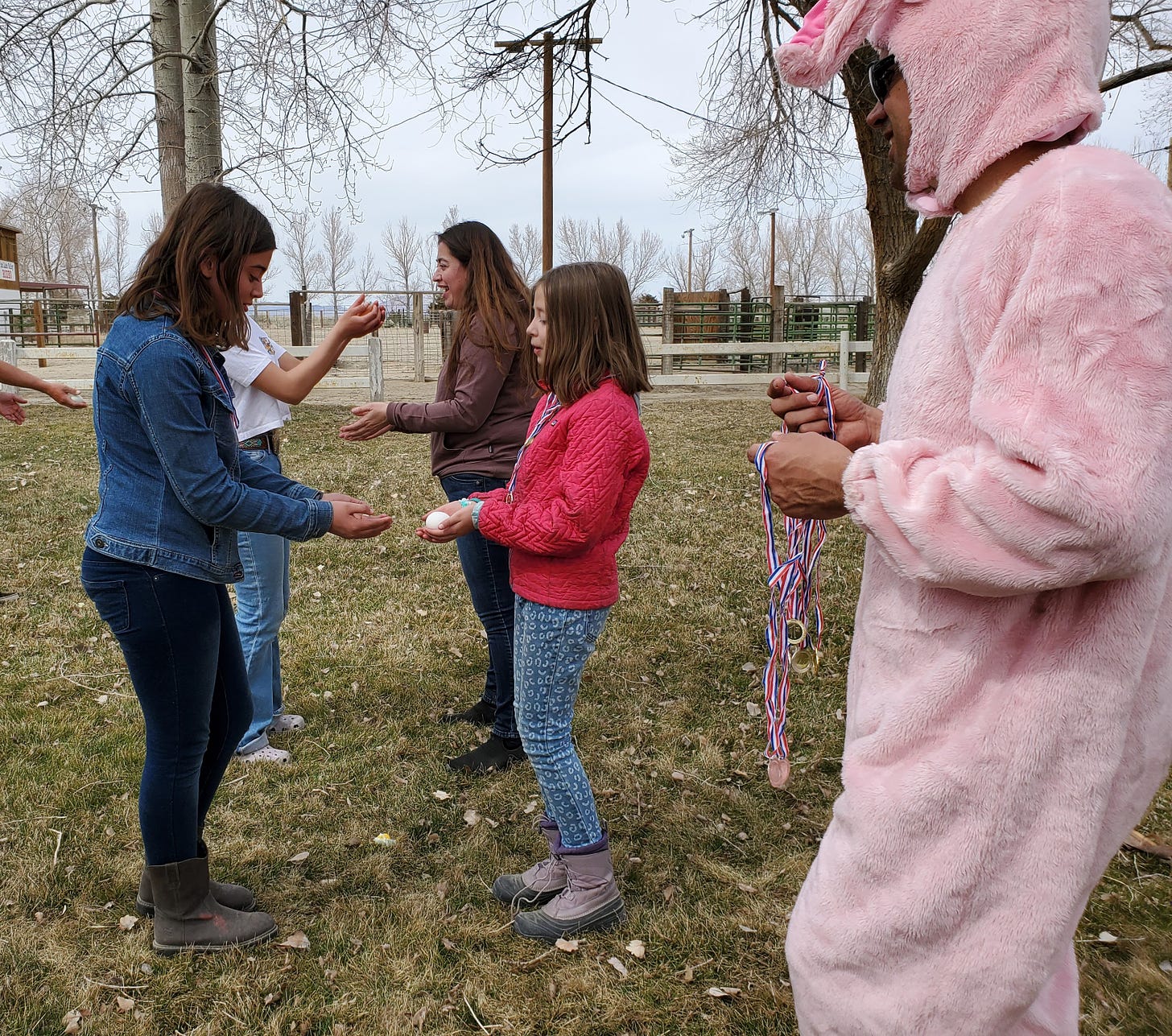 C and L tossing each other an egg. Eric looks on in a pink bunny suit.