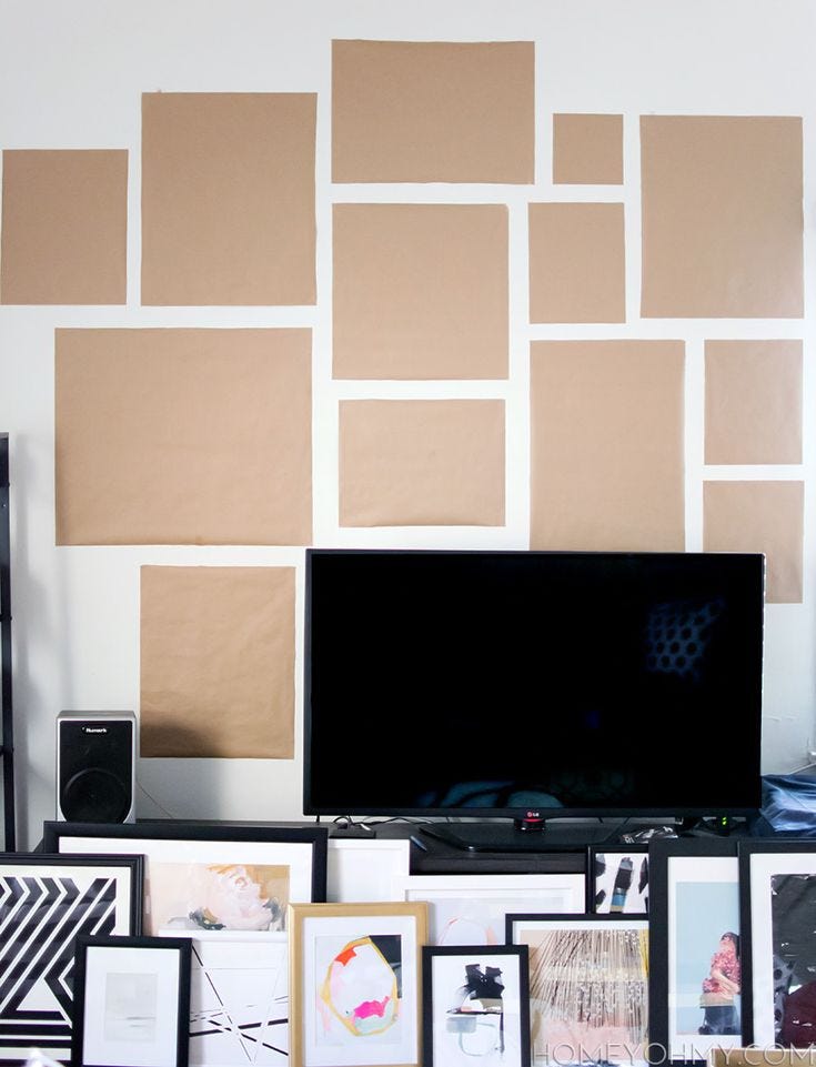 This may contain: a flat screen tv sitting on top of a wooden table next to a wall covered in pictures This may contain: a flat screen tv sitting on top of a wooden table next to a wall covered in pictures